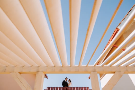 Silhouettes of the bride and groom in not full height, standing against the background of the voluminous blue sky. Artistic photo. photo