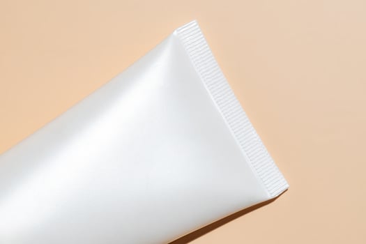 mockup of white squeeze bottle plastic tube for branding of medicine or cosmetics - cream, gel, skin care, toothpaste. Cosmetic bottle container on a beige background. Minimalism photo