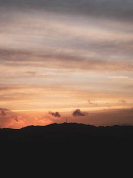 Silhoute of a windmill on top of a hill with golden hues photo