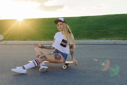 Portrait of a hipster young girl smiling with a longboard at sunset. photo