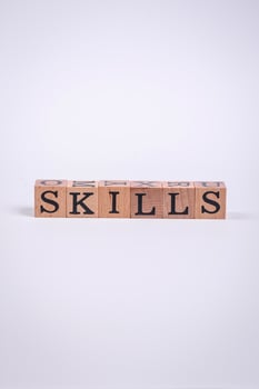The inscription Skills made of wooden cubes on a plain background photo