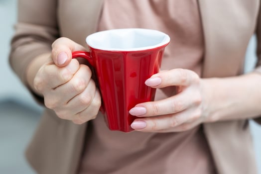 Woman holding mug of hot drink, closeup. Coffee Break photo