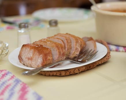 sliced pork roast on the table ready for a family dinner photo