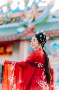 Woman dress China New year. portrait of a woman. person in traditional costume. woman in traditional costume. Beautiful young woman in a bright red dress and a crown of Chinese Queen posing. photo