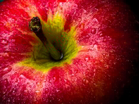 Water droplet on glossy surface of red apple on black background photo
