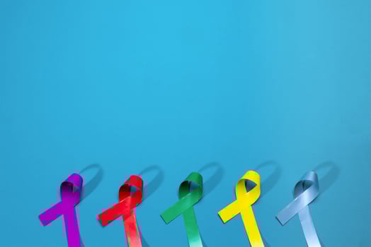World cancer day background. Colorful ribbons, cancer awareness. blue surface from above. photo