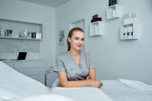 Young beautiful cosmetologist in cosmetology cabinet photo