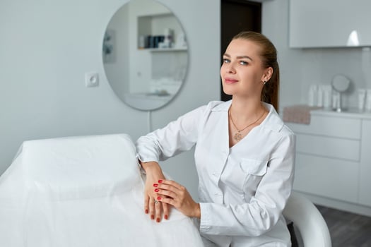 Consultation in cosmetology clinic. Female beauty doctor in white coat and black gloves crossed hands. Healthcare concept. photo