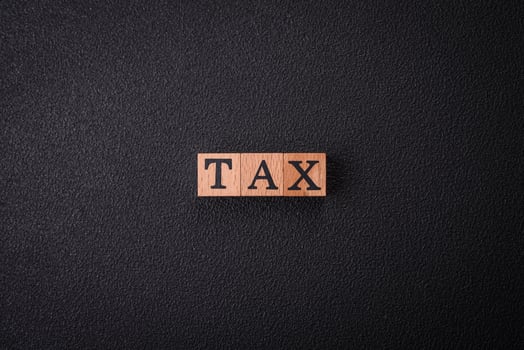 The inscription Tax made of wooden cubes on a plain background photo