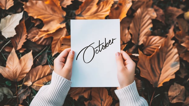AI generated Hands holding a sheet of paper with the word october in autumn leaves background photo