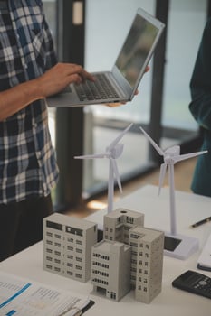Electrical engineer with businessman discussing new project installation solar cell panel on the roof of building. Alternative energy concept. photo