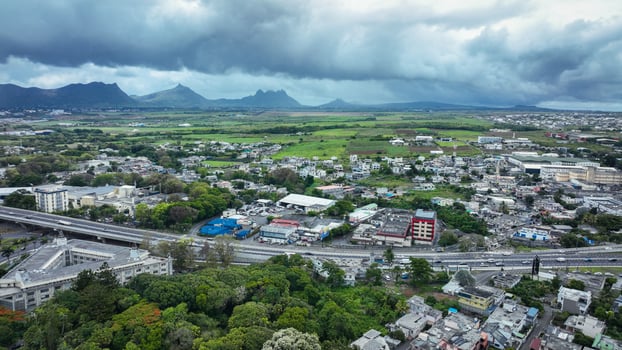 An aerial photograph capturing the city of Quatre Bornes with majestic mountains forming a stunning backdrop. photo