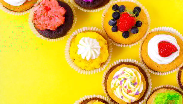 AI generated many different cupcakes on a yellow background photo