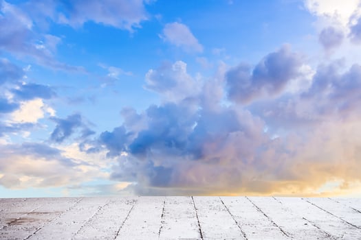 Dainty wispy pale salmon pink and golden yellow clouds at sunset with cement floor photo