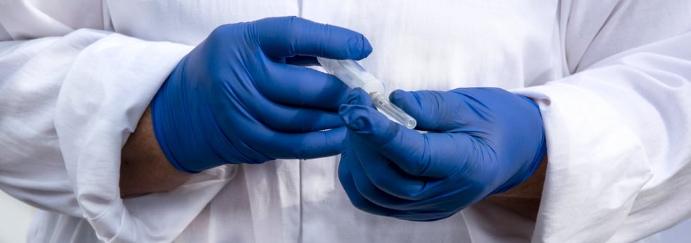 Hands in blue gloves with a syringe. photo
