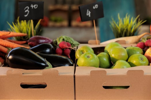 Various organic farmers market products locally grown, natural ripe fruits and vegetables pn table. Seasonal bio fresh eggplants, carrots and juicy sweet apples in boxes. Organic farming. photo