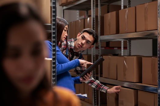 Warehouse operators preparing order for dispatching and choosing cardboard box. Asian logistics and distribution manager supervising inventory quality control in storehouse photo