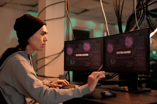 Asian hacker looking at firewall encryption to hack server, working with virus to steal personal information. Young thief causing security breach alert after breaking into computer system. photo