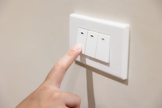 people press light switch to turn off the light for saving home energy reduce utilities billing cost photo