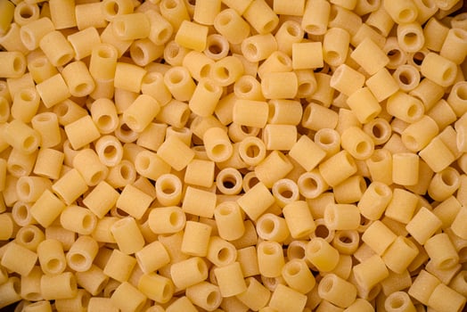Raw ditali pasta made from durum wheat on a dark concrete background photo