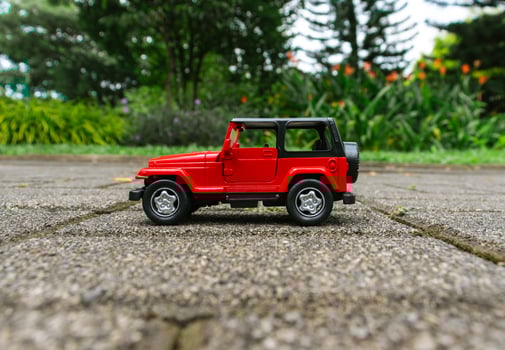 Concept for travelling with a car. Photo of a toy car placed in the park, after some edits.