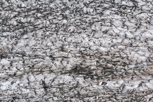 surface of a melting mountain glacier covered with dust and rubble photo