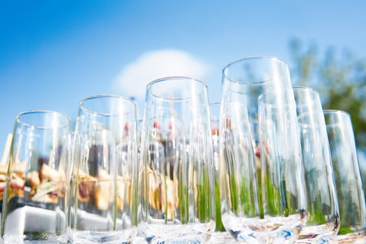 buffet in the open air - empty glasses on the background of cold snacks against the sky photo