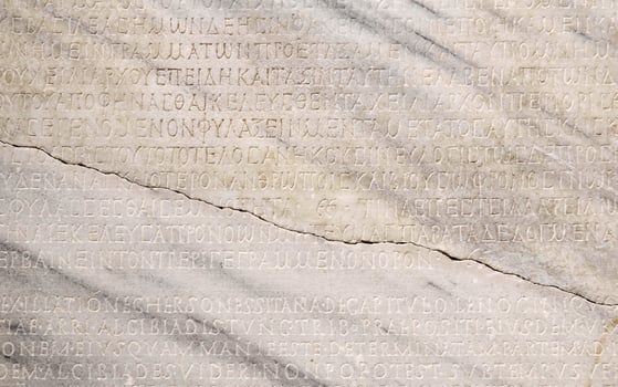 fragment of a marble slab with a carved text on the collection of taxes in ancient Greek from Chersonesos, Crimea photo