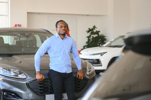 Car Buyer. Black Guy Choosing New Automobile In Dealership Store photo