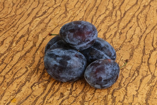 Ripe plum heap over background photo