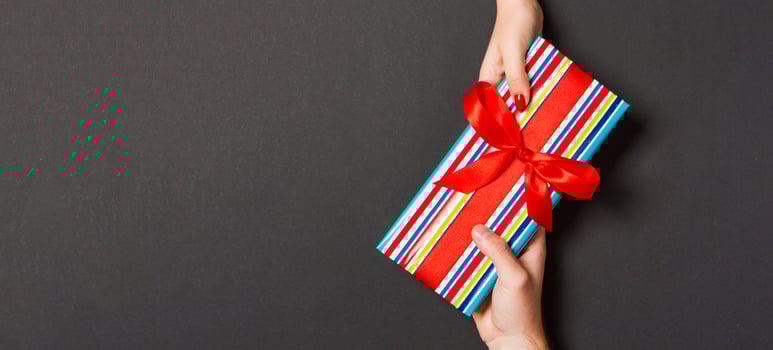 Top view of giving a present to a lovely person on colorful background. Couple congratulate each other. Festive concept. Copy space photo