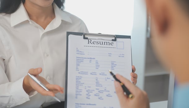 Close up view of job interview in office, focus on resume writing tips, employer reviewing good cv of prepared skilled applicant, recruiter considering application, hr manager making hiring decision photo