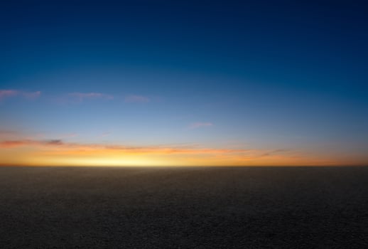 Sunset Sky,Cloud Background,Horizon Evening Summer twilight dusk sky with gloomy vivid blue, yellow, orange with sunlight reflecting on dark concrete floor texture or rough asphalt street pavement photo