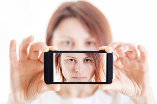 pretty woman taking a selfie using her smartphone photo