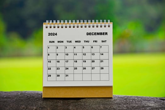 December 2024 white calendar with green blurred background. photo