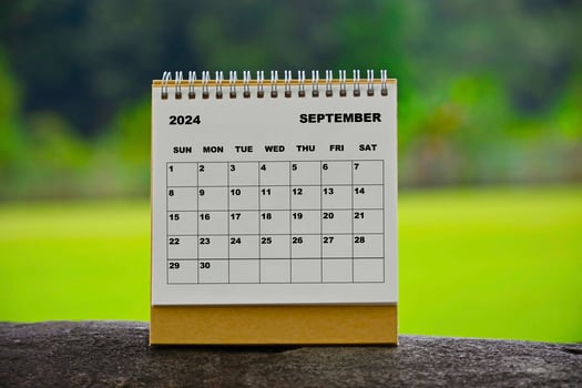 September 2024 white calendar with green blurred background. photo