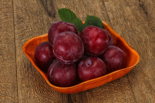 Plum heap in the wooden basket photo