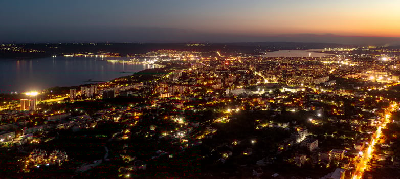 A panoramic aerial view of the city near sea at night. photo