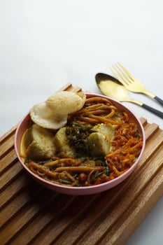 Lontong with curry soup accompanied by fried sweet potatoes chili sauce and noodles photo