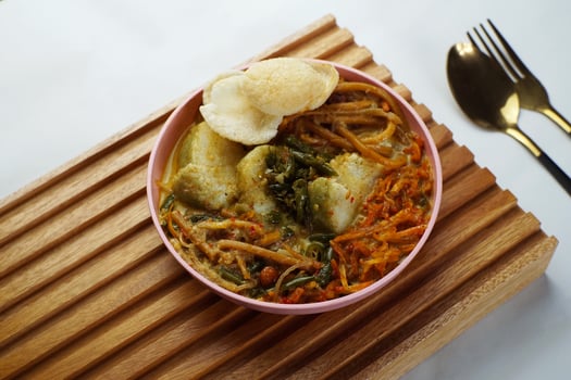 Lontong with curry soup accompanied by fried sweet potatoes chili sauce and noodles photo