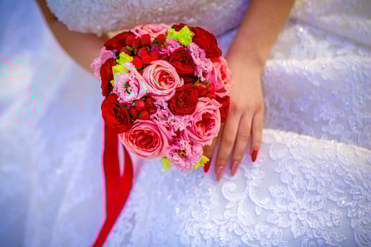 Bride Holding Red and Pink Flower Bouquet photo