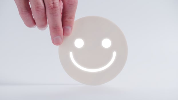 Customer service evaluation and satisfaction survey concepts. The client's hand picked the happy face smile face icon on circle wood photo