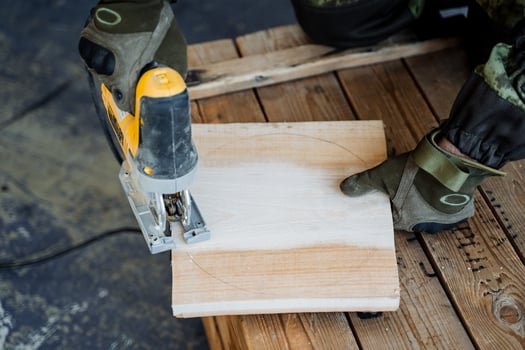 Creating a plate from natural material. Round wooden plate. A close shot of the hands of a master woodcarver. Carving a round plate from a square piece of wood. photo