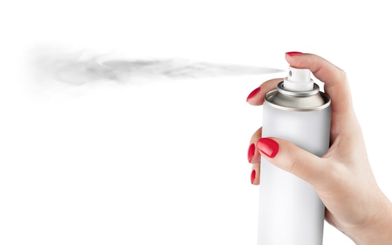 Woman hand with a can of spray paint. Isolated on white background. photo