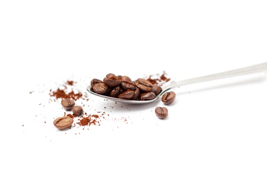 Spoon with coffee beans isolated on white photo
