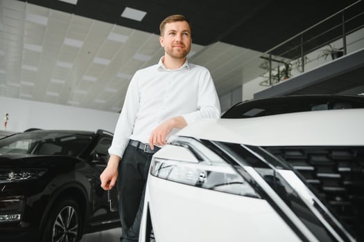 Happy customer just bought a car at car dealership photo