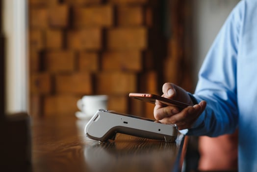Mature businessman paying with contactless credit card with NFC technology. photo