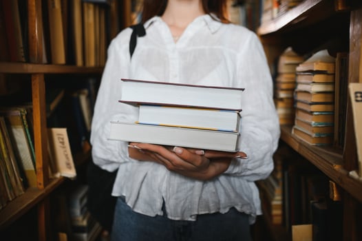in the library - pretty female student with books working in a high school library. photo
