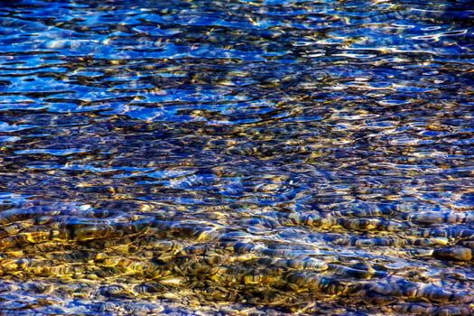 Background of the water of Lake Traunsee in the coastal area. Colorful texture of stones under water photo