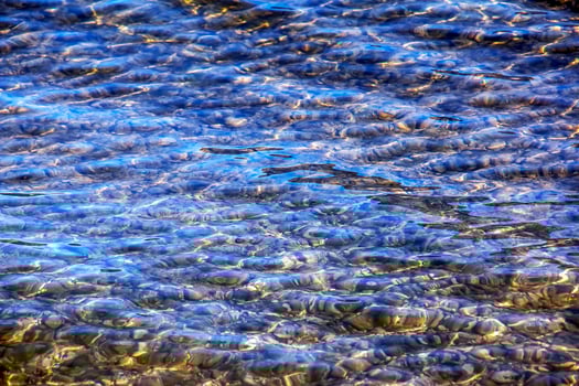 Background of the water of Lake Traunsee in the coastal area. Colorful texture of stones under water photo